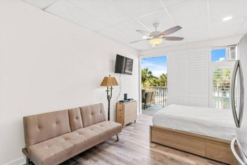 1 dormitorio con 1 cama y ventilador de techo en Dolphin Watch, en Clearwater Beach