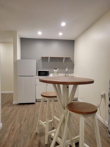 a kitchen with a wooden table and two stools at The Honey Bee Motel in Dunlap