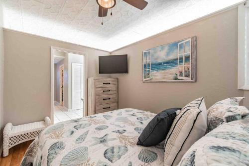 a bedroom with a bed and a flat screen tv at Seaside Serendipity in Clearwater Beach