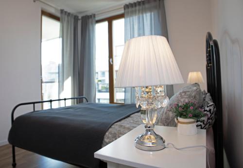 um quarto com uma cama e um candeeiro sobre uma mesa em Luxus Apartament Rodzinny z sauną i siłownią em Gdansk