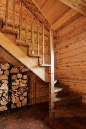 a wooden staircase in a log cabin with a pile of logs at House of Sparkles in Elektrėnai
