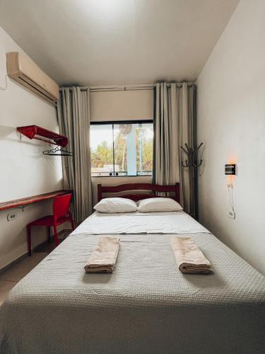 um quarto com uma cama grande com duas toalhas em Pousada Casa Boa Milagres em Barra do Camaragibe
