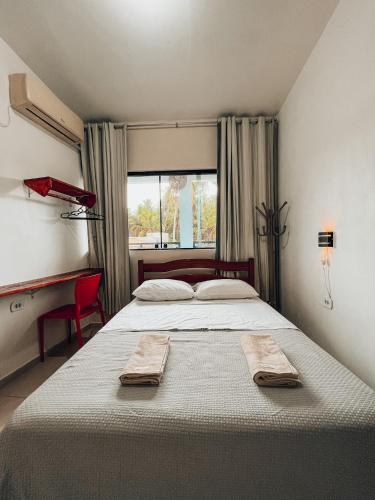 a bedroom with a large bed with two towels on it at Pousada Casa Boa Milagres in Barra do Camaragibe