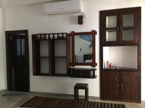 a room with a mirror and a wooden cabinet at Avendra Holiday Inn Weligama in Weligama