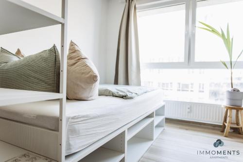 białe łóżko piętrowe w pokoju z oknem w obiekcie Serviced Apartment mit Netflix und WLAN im Zentrum WE 04 w mieście Magdeburg
