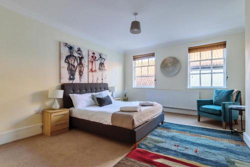 a bedroom with a bed and a blue chair at 37a Stonegate Loft in York