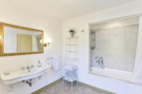 a bathroom with a sink and a tub and a mirror at Villa Cielo Blu - Homelike Villas in Montecatini Terme