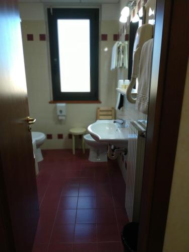a bathroom with a sink and a toilet and a window at Hotel Aurora in Tivoli Terme