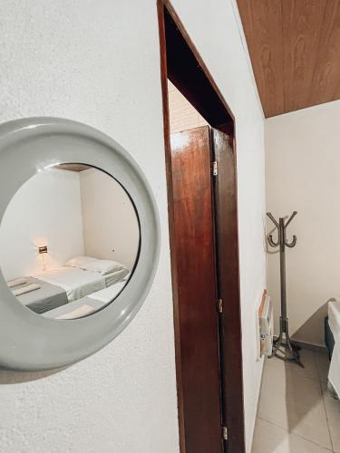 a mirror on a wall with a bed in a room at Pousada Casa Boa Milagres in Barra do Camaragibe