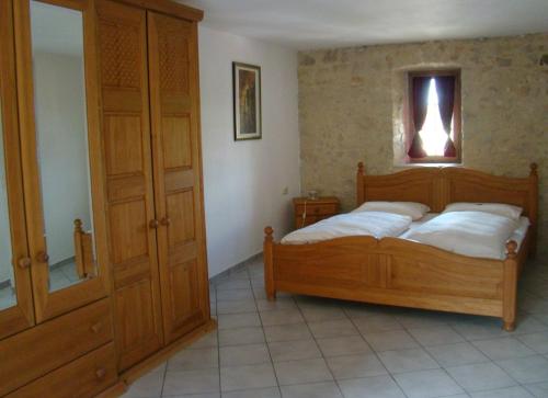 Schlafzimmer mit einem Holzbett und einem Spiegel in der Unterkunft Burg Katzenstein in Katzenstein