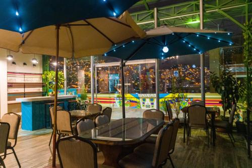 a table and chairs with umbrellas in a restaurant at Hotel Las Brisas Centro in La Paz