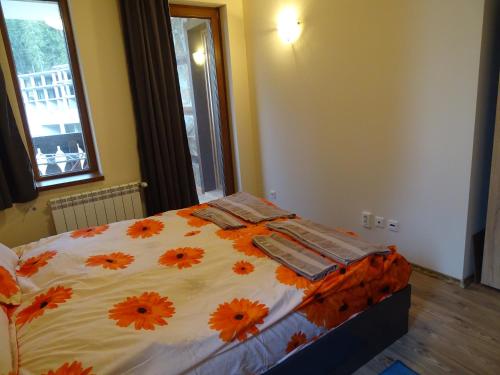 a bedroom with a bed with orange flowers on it at APARTMENT Darsi in Pamporovo