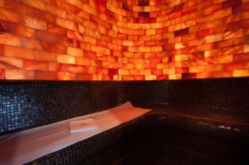 a bench in a room with a wooden wall at Xavin Wellness Hotel & Restaurant in Harkány