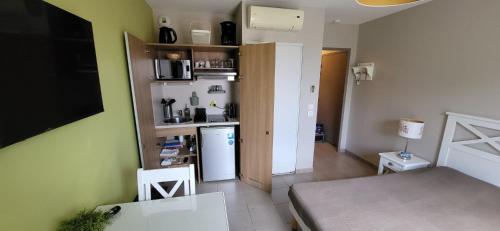 Cette petite chambre comprend une cuisine équipée d'un réfrigérateur. dans l'établissement Studio Résidence 3 étoiles Odalys Les Océanides Piscine Plage Argentière parking boite à clé, à La Londe-les-Maures