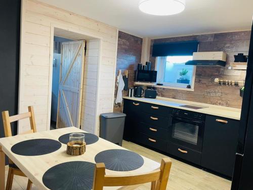 a kitchen with a table and chairs and a kitchen with a stove at Apartmán Kunst in Kořenov