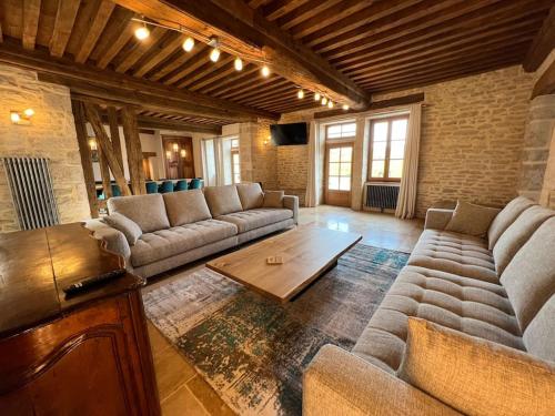 Sala de estar con sofás y mesa de centro en La Bastide De Chassagne-Montrachet, en Chassagne-Montrachet