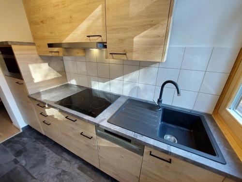 a kitchen with a sink and a counter top at Bad Kleinkirchheim RMG family apartments in Bad Kleinkirchheim