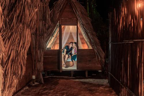 a couple kissing in a window at night at Mapache Hostel & Camping in Holbox Island
