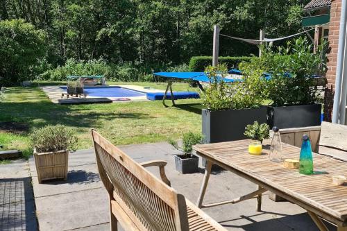 een patio met een tafel en stoelen en een zwembad bij Balistyle guesthouse in the forest near Amsterdam in Velsen-Zuid