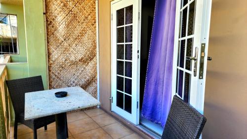 una mesa pequeña y 2 sillas en un porche en Caribic House, en Montego Bay