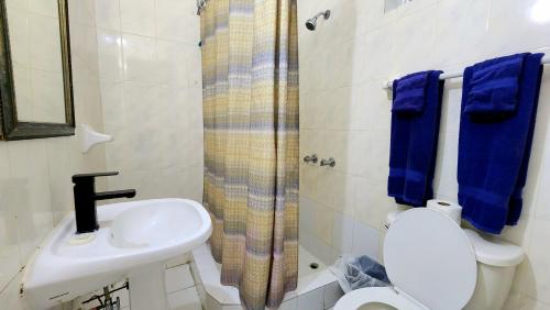 a bathroom with a sink and a toilet and a shower at Caribic House in Montego Bay