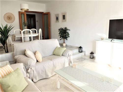 a living room with a white couch and a table at Luxury apt Alamos beach Torremolinos (Costa Lago) in Torremolinos