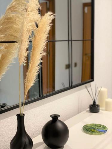 a black vase sitting on a counter with a mirror at Luxury apartments Alamos beach Torremolinos - Costa Lago in Torremolinos