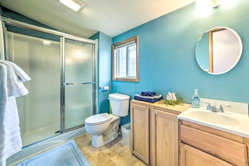 a bathroom with a toilet and a sink and a shower at Higgins Lake Retreat - Hike, Swim, Relax! in Roscommon