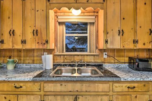 uma cozinha com um lavatório e uma janela em Cozy Graham Retreat about 3 Mi to Lake Eddleman! em Graham