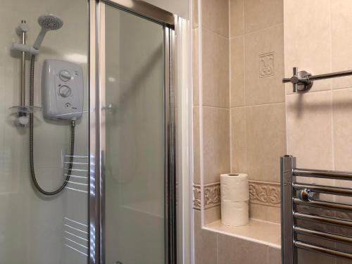 La salle de bains est pourvue d'une douche avec une porte en verre. dans l'établissement Distillery Guest House, à Fort William
