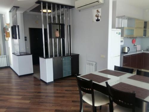 a kitchen with a table with chairs and a refrigerator at Апартаменты на набережной с панорамным видом на 39 этаже in Astana