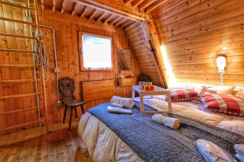 una camera con un letto in una baita di tronchi di ~Chalet_Rifugio tra i boschi~ a Sella Nevea