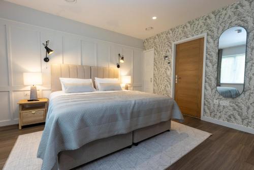 a bedroom with a large bed and a mirror at The Kingswood in St Austell