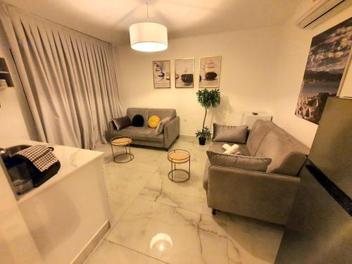 a living room with two couches and a table at Barak Royal suites VIP 134 - חמש דקות מהים ומהטיילת in Eilat