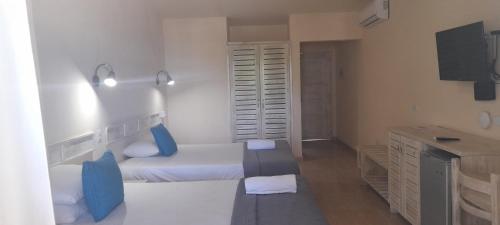 1 dormitorio con 2 camas, escritorio y lavamanos en guest house MY WAY en Las Terrenas