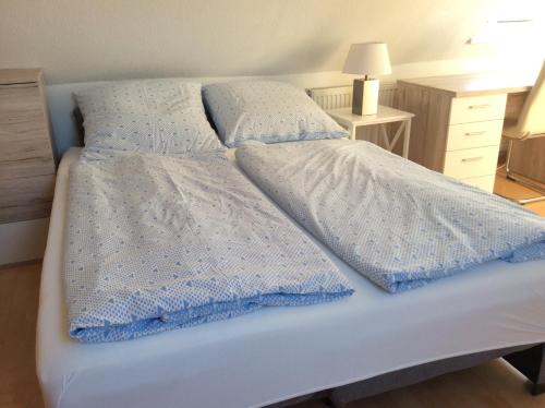 Una cama con una manta azul y blanca. en Ferienwohnung Lini, en Schwerin