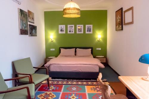 1 dormitorio con cama y pared verde en Old Radio hostel, en Samarkand
