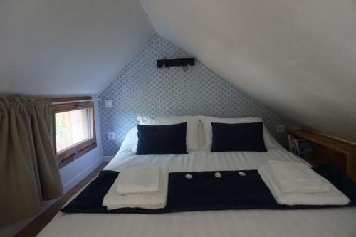 - une chambre avec un lit blanc et une fenêtre dans l'établissement A LA BELLE ECORCE- tiny house, à Turenne