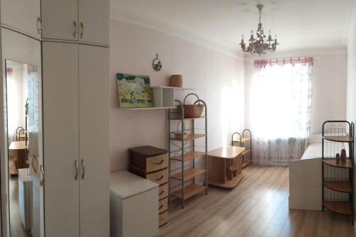a bedroom with white walls and wooden floors and a window at AURA on Erkindik boulevard in Bishkek