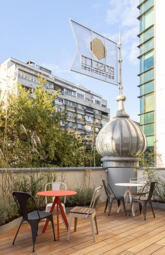 a patio with chairs and a table and a sign at Rosetti Hotel in Bucharest