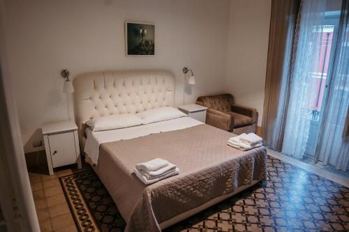 a bedroom with a large bed with two towels on it at Elephant's Smile B&B in Catania