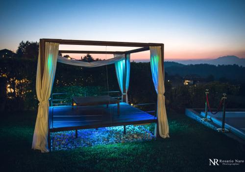 a canopy bed with blue lights in the grass at Villa Ghiringhelli in Azzate