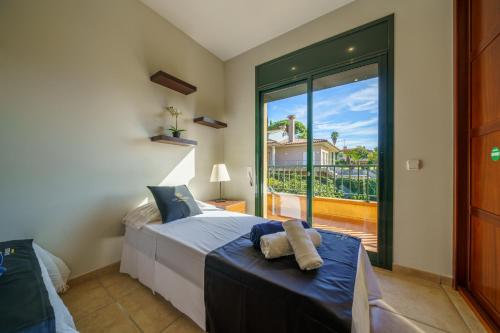 Schlafzimmer mit einem Bett und einem großen Glasfenster in der Unterkunft VIlla Jaruco Lux, exclusiva zona residencial con Piscina & Aircon in Lloret de Mar