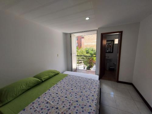 a bedroom with a bed and a door to a balcony at Apartamento Laureles la 33 in Medellín