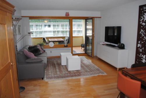 a living room with a couch and a tv at Rose Davos in Davos