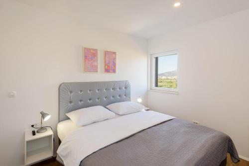 a white bedroom with a large bed with a window at Neretva Valley Apartments - Heated Pool in Metković