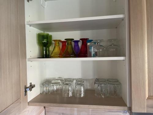 a cabinet filled with glass jars and vases at Dore in Lielvārde