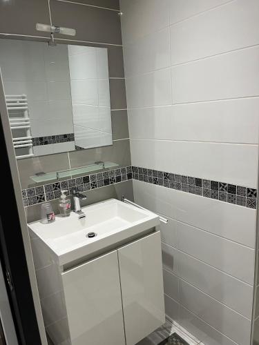 Baño blanco con lavabo y espejo en Loubat Christophe, en Millau