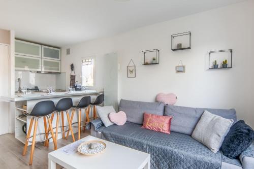 a living room with a blue couch and a kitchen at Charming duplex with big terrace- Cabourg - Welkeys in Cabourg