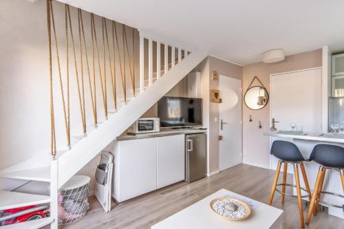 Charming duplex with big terrace- Cabourg - Welkeys في كابورغ: مطبخ وغرفة معيشة مع درج في شقة